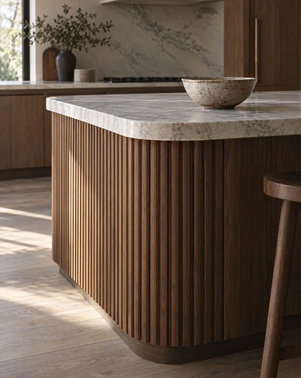 Fluted walnut kitchen island base with a thick honed marble top
