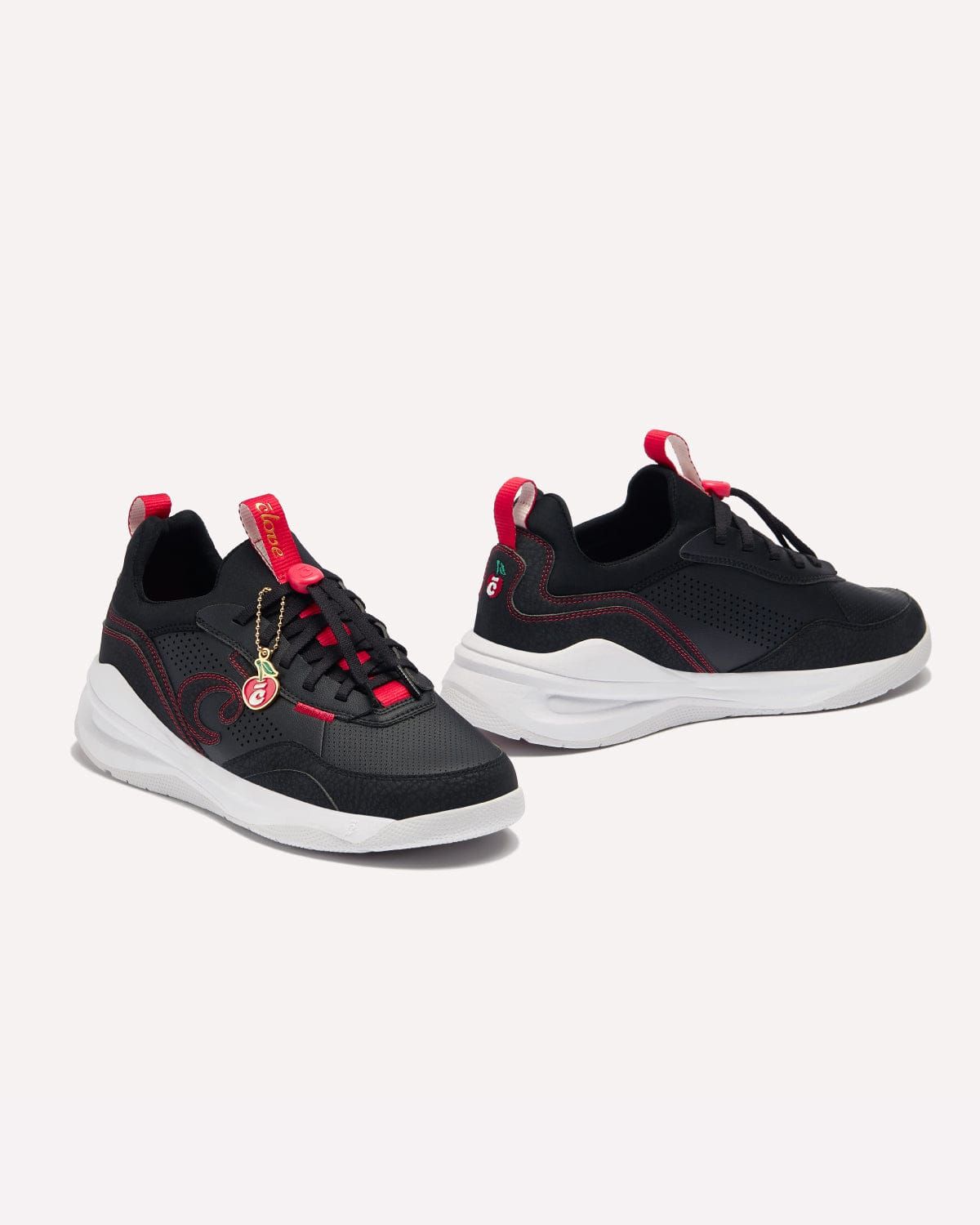 a pair of black and red sneakers on a white background