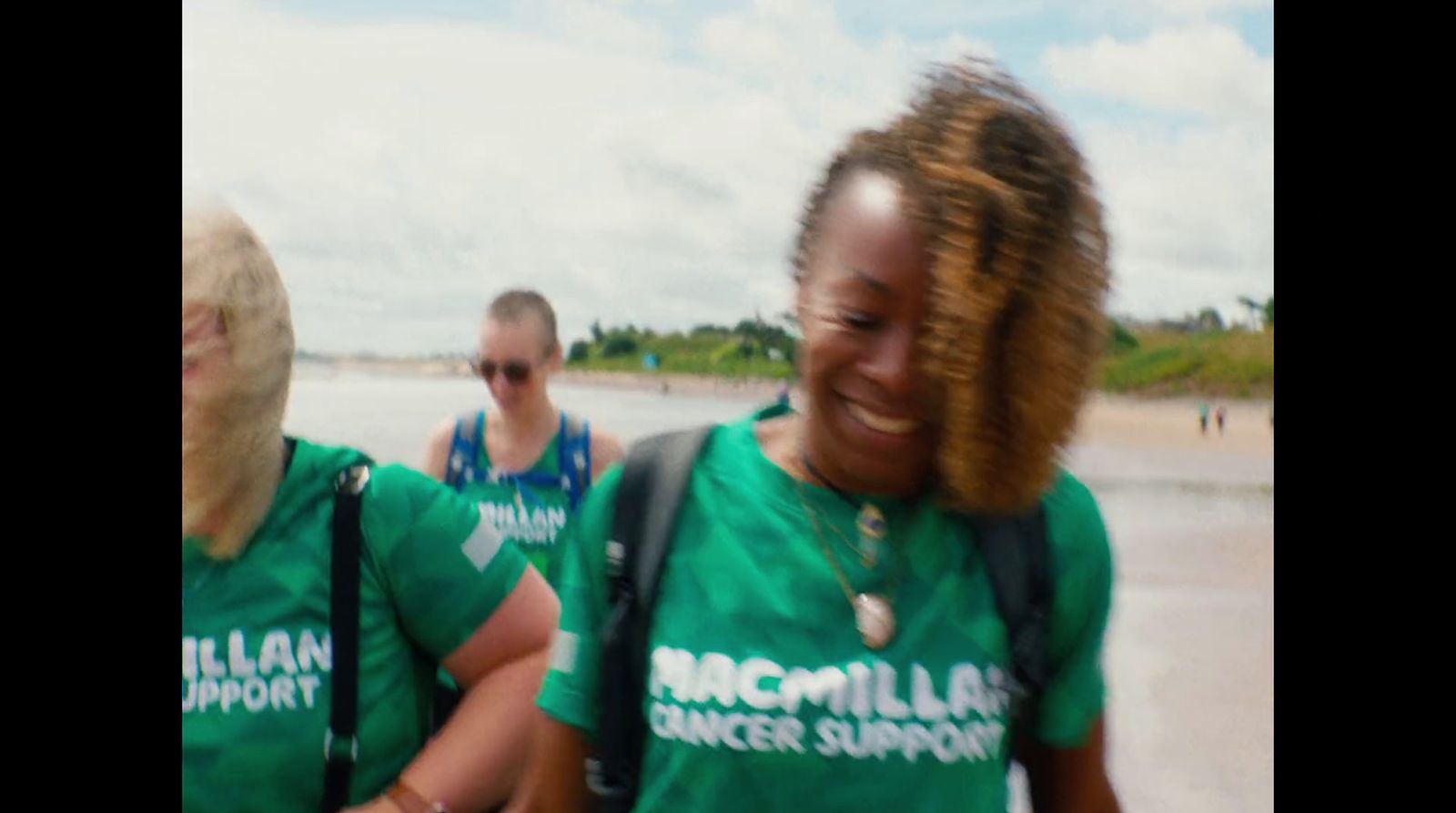 a group of people walking along a beach