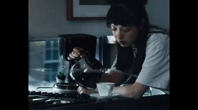 a woman pouring a cup of coffee into a cup