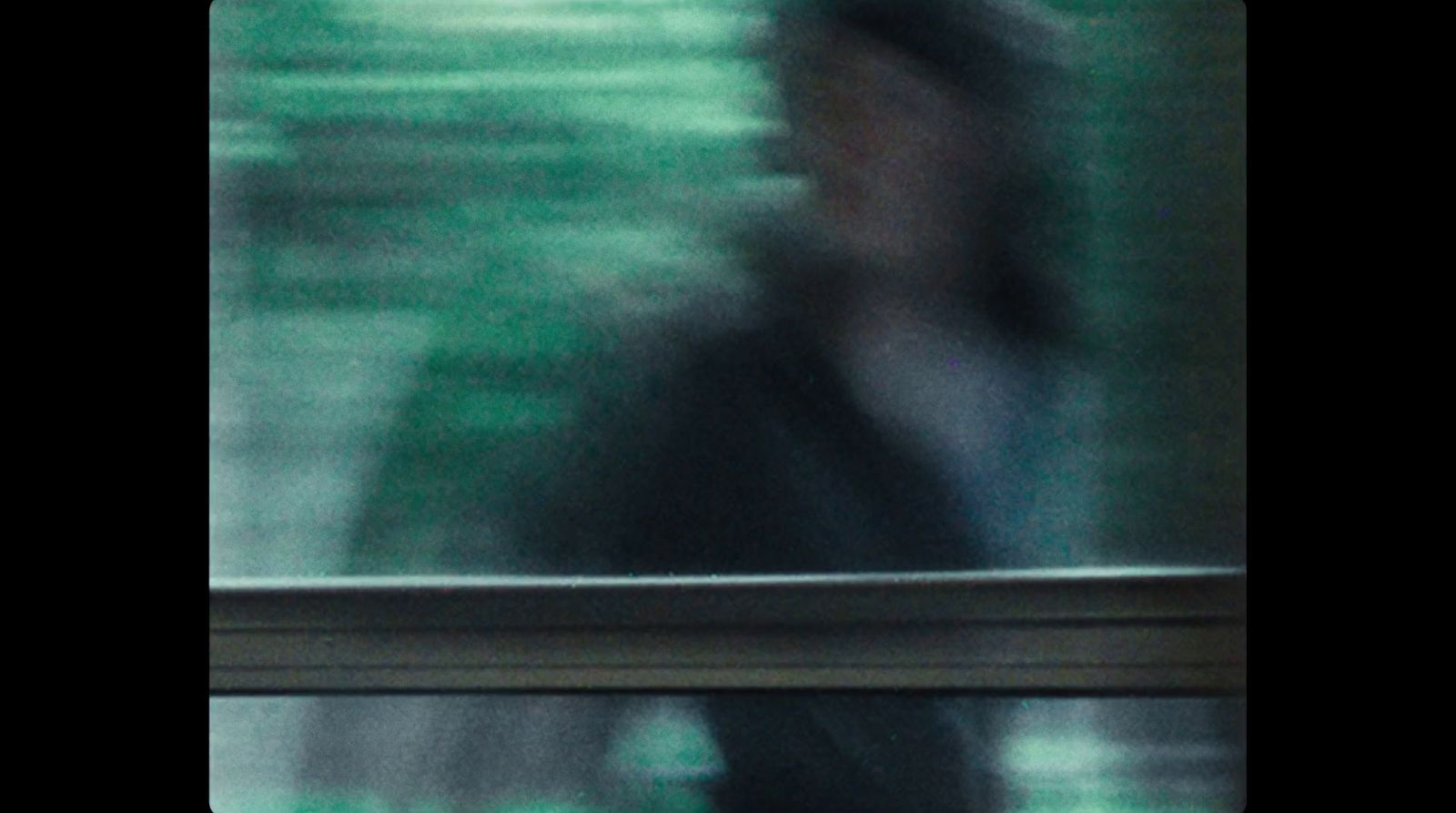 a blurry photo of a man walking by a window