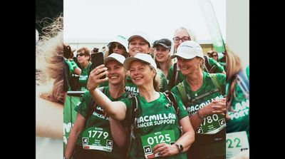 a group of women in green shirts taking a picture