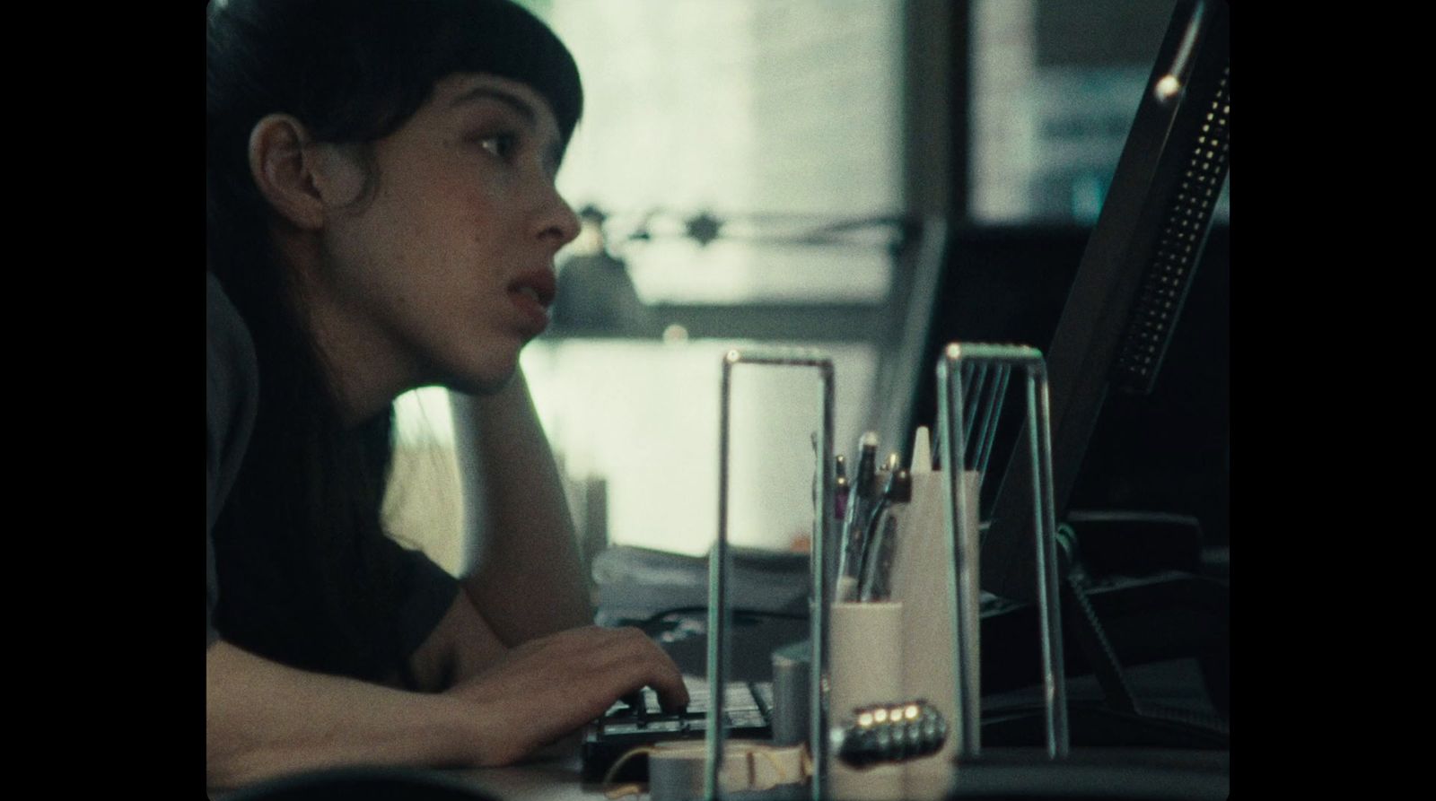 a woman sitting at a desk in front of a computer