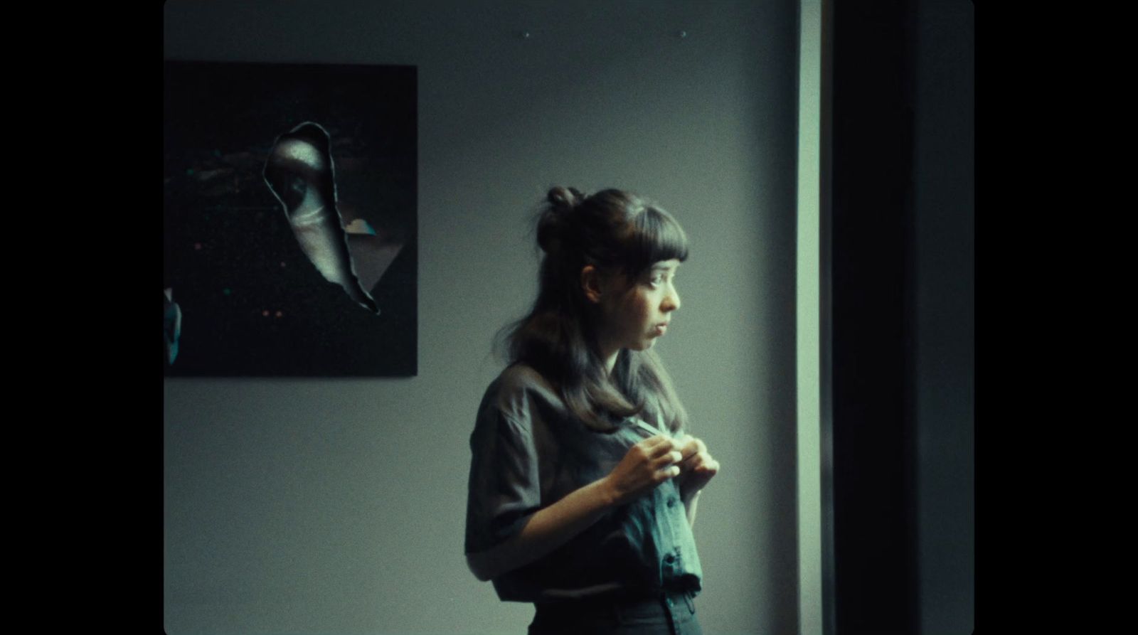 a woman standing in front of a window with a pair of shoes on the wall