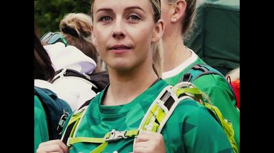 a woman wearing a green shirt and carrying a backpack