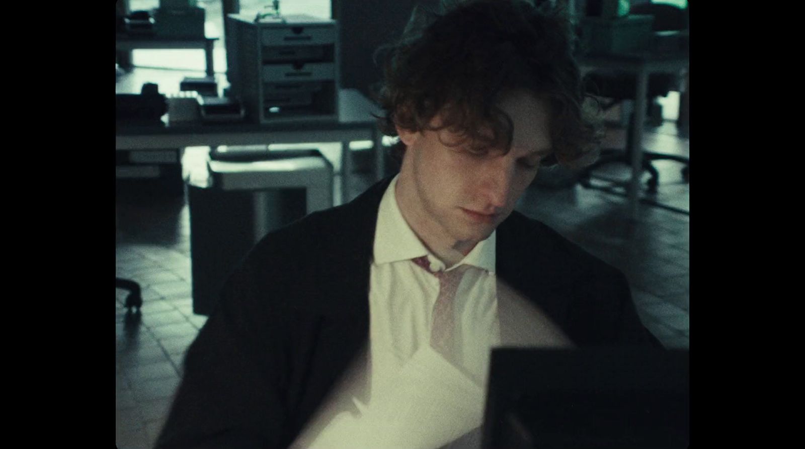 a man in a suit and tie looking at a computer screen