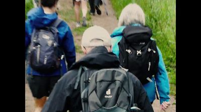 a group of people walking down a dirt road