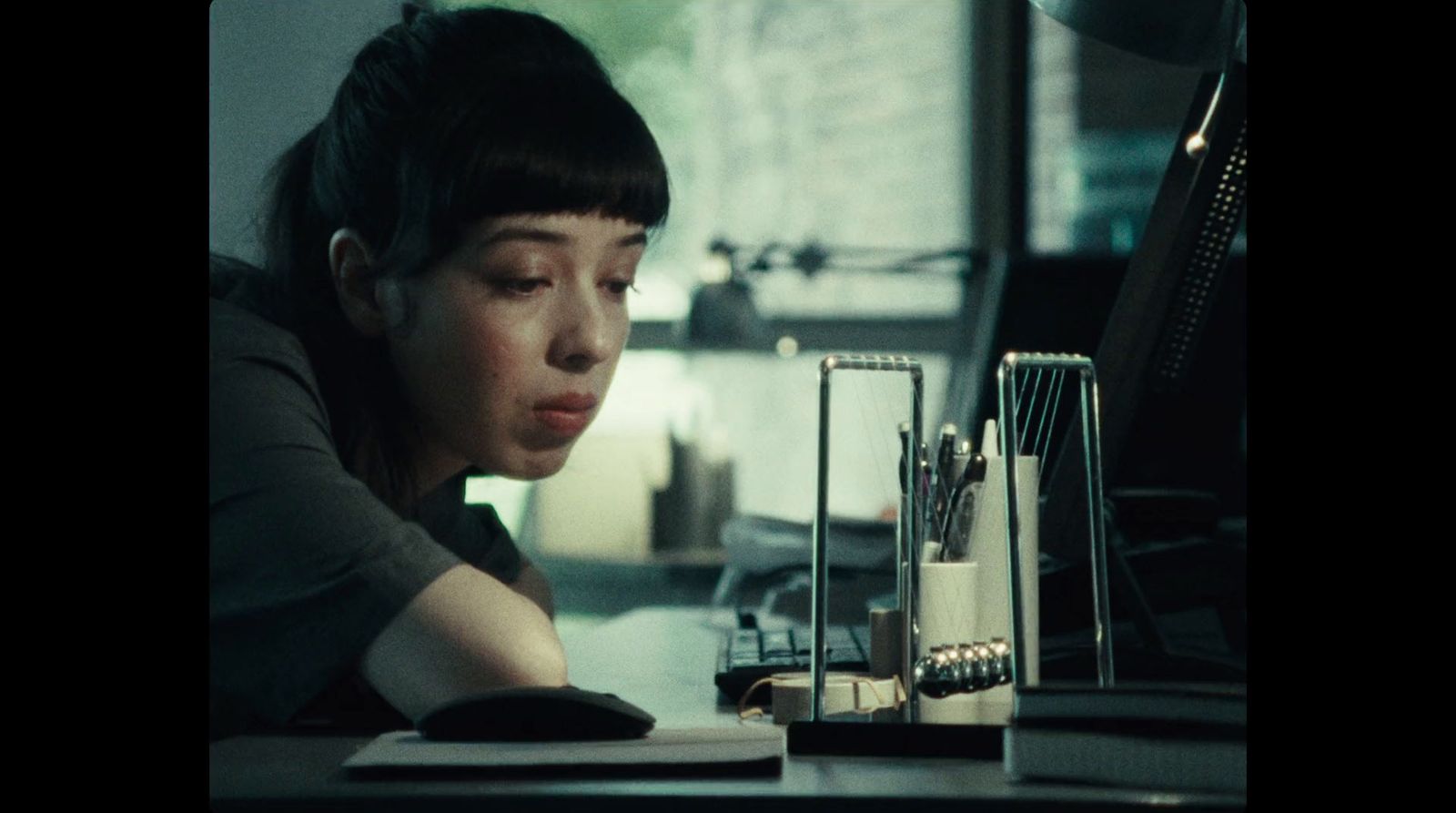 a woman sitting at a desk in front of a computer