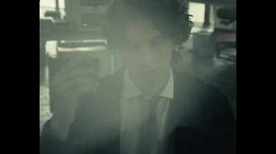 a woman wearing a suit and tie in a dark room