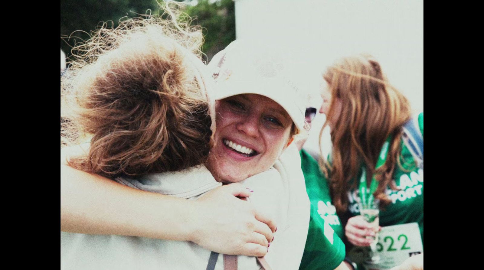 two women hugging each other in the middle of a race