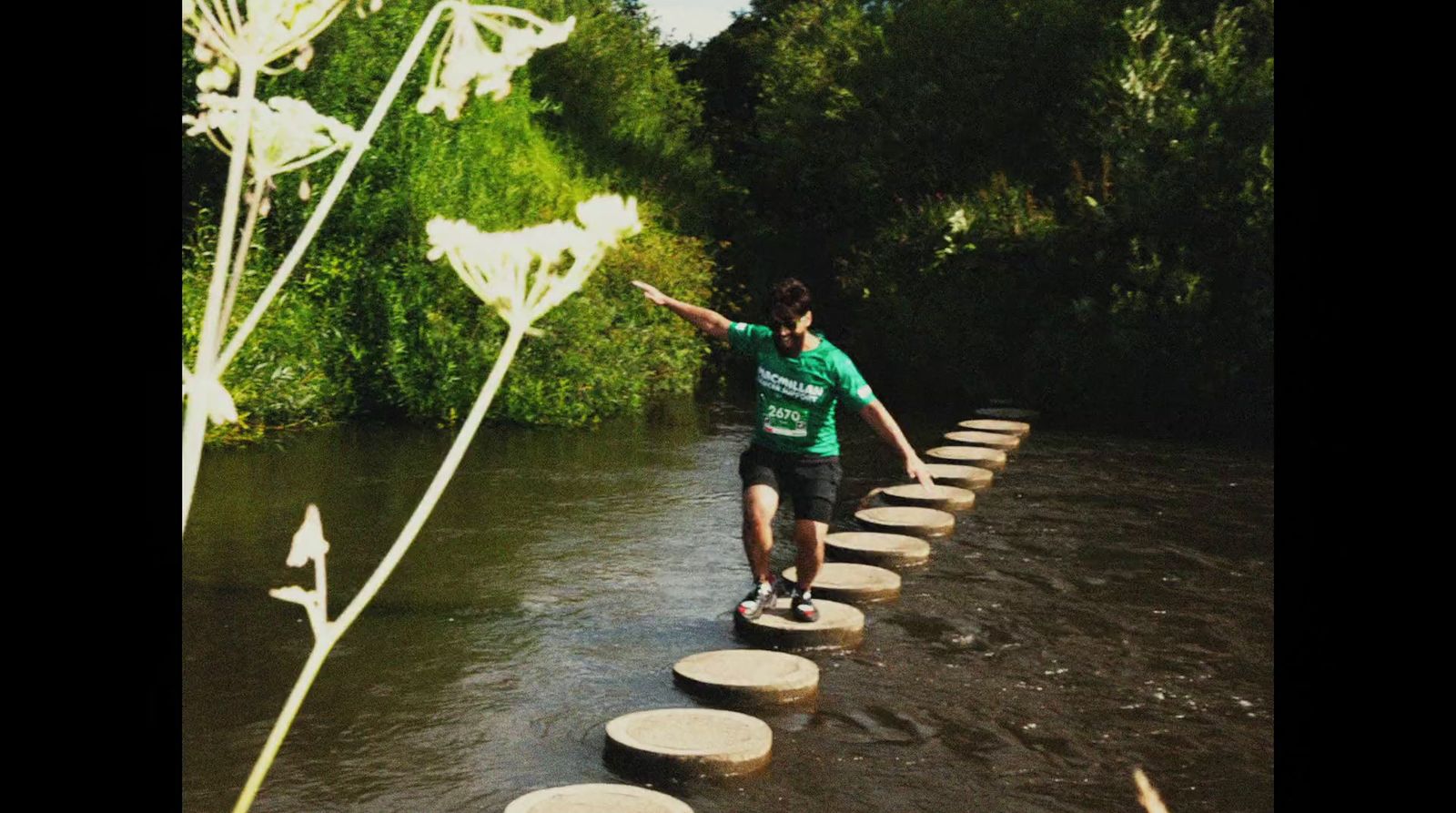 a man walking across stepping stones across a river