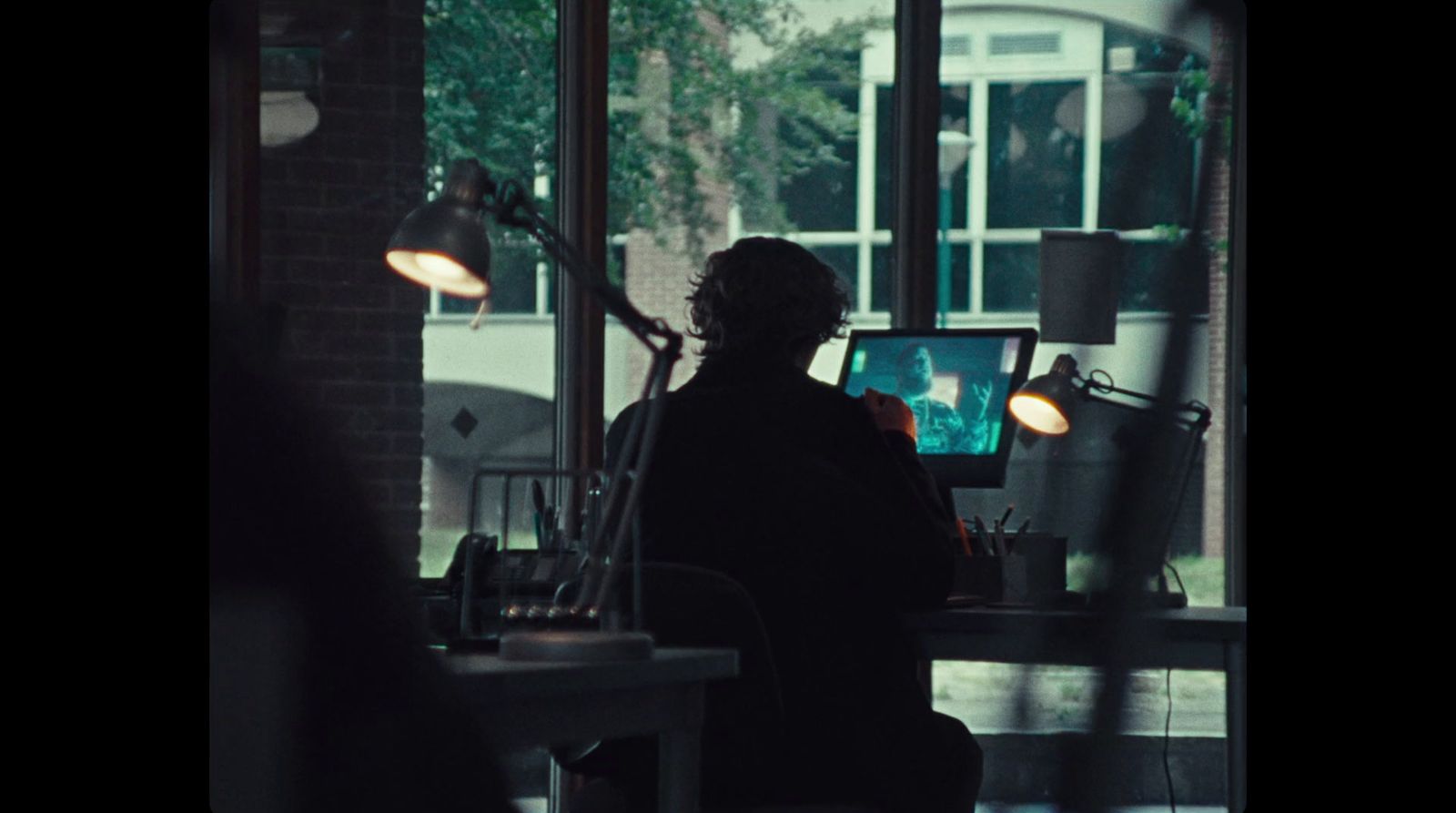 a person sitting at a desk in a dark room