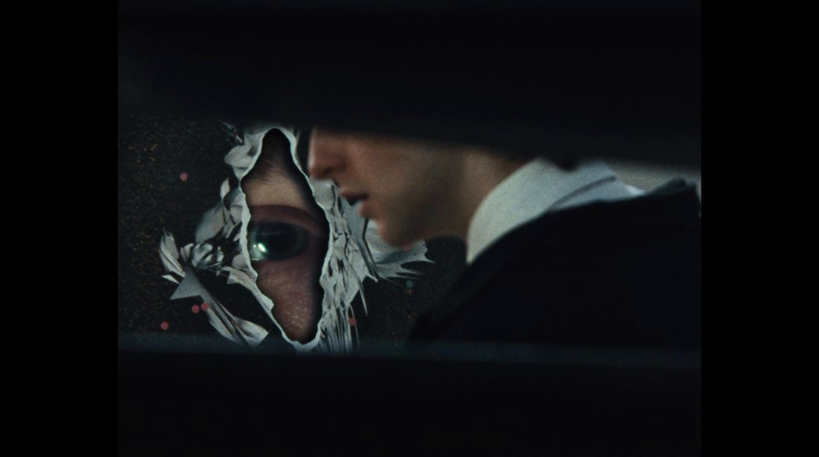 a man and a woman looking at each other through a hole in a piece of