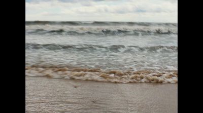 a blurry picture of a wave coming in to the shore