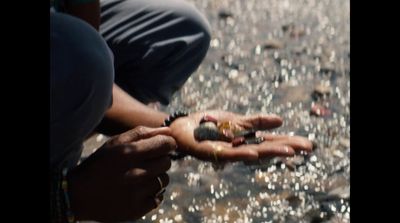 a person kneeling down holding something in their hand