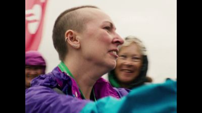 a woman with a shaved head standing next to another woman