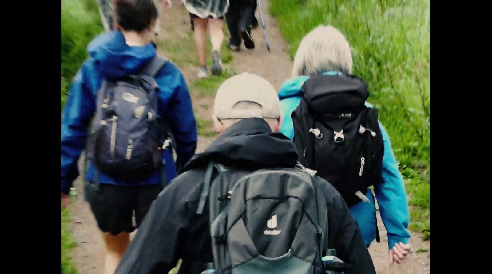 a group of people walking down a dirt road