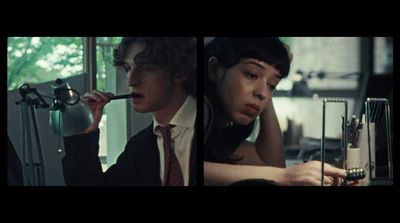 a man in a suit and tie smoking a cigarette