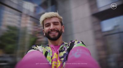 a man with blonde hair and a beard wearing a pink shirt