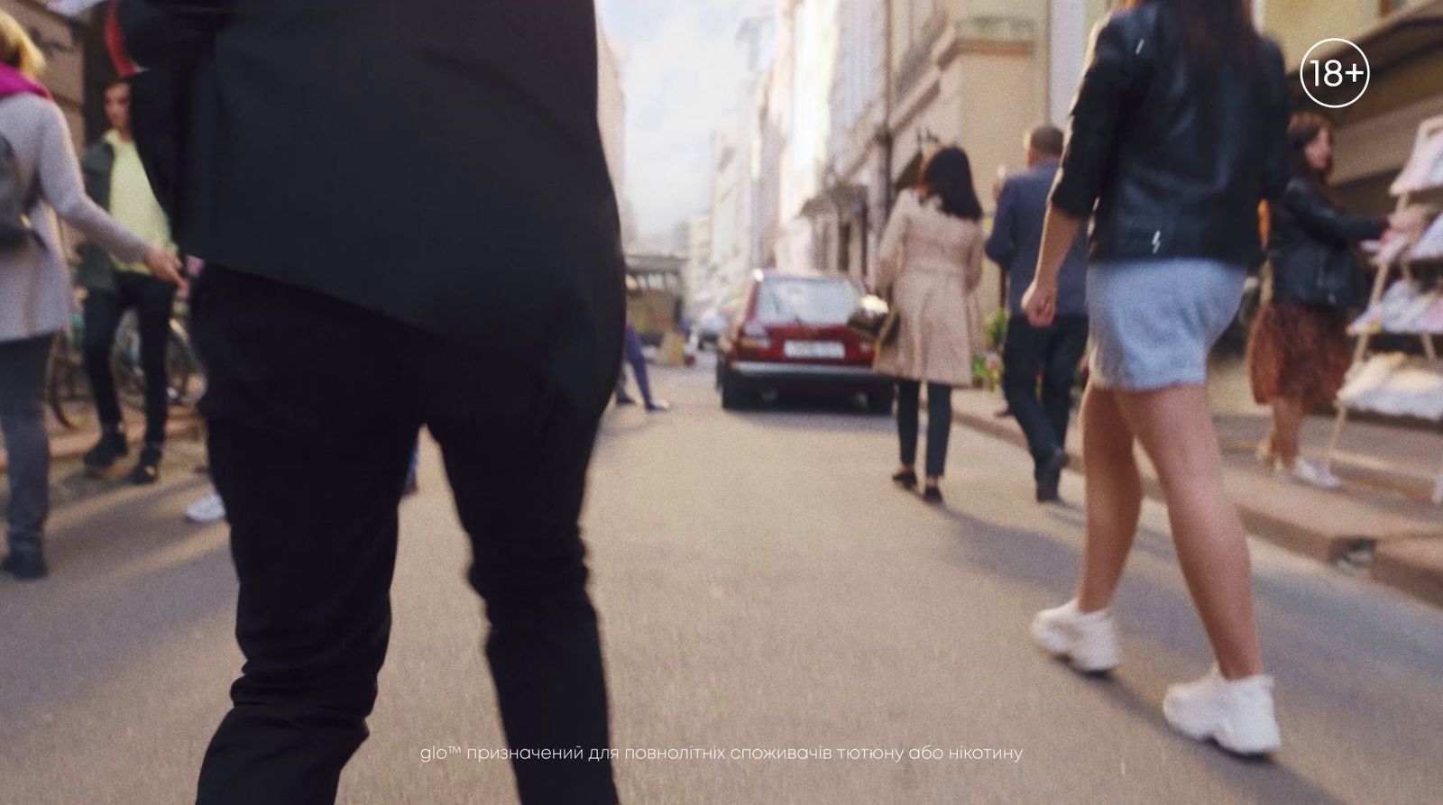 a group of people walking down a street next to tall buildings