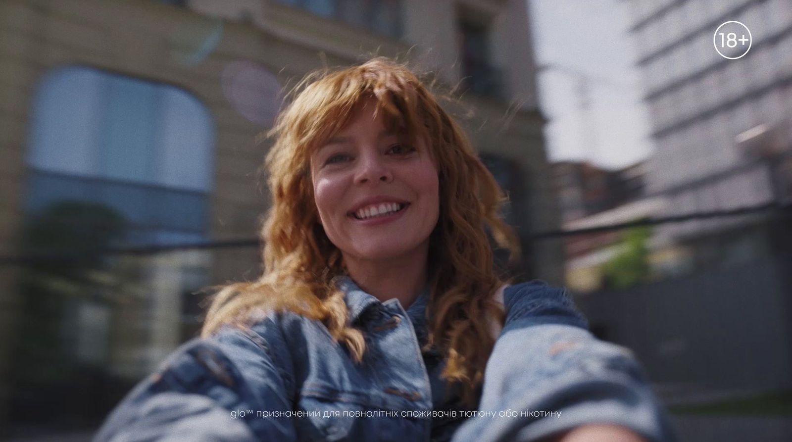 a woman with red hair and a denim jacket