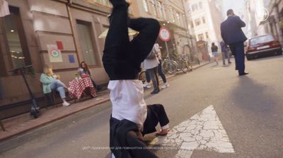 a man in a white shirt is doing a handstand on a city street