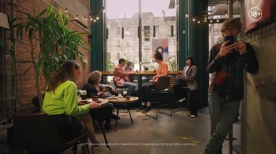 a group of people sitting at tables in a restaurant