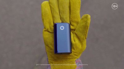 a person wearing a yellow glove holding a blue device