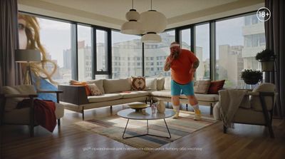 a man standing in a living room next to a couch