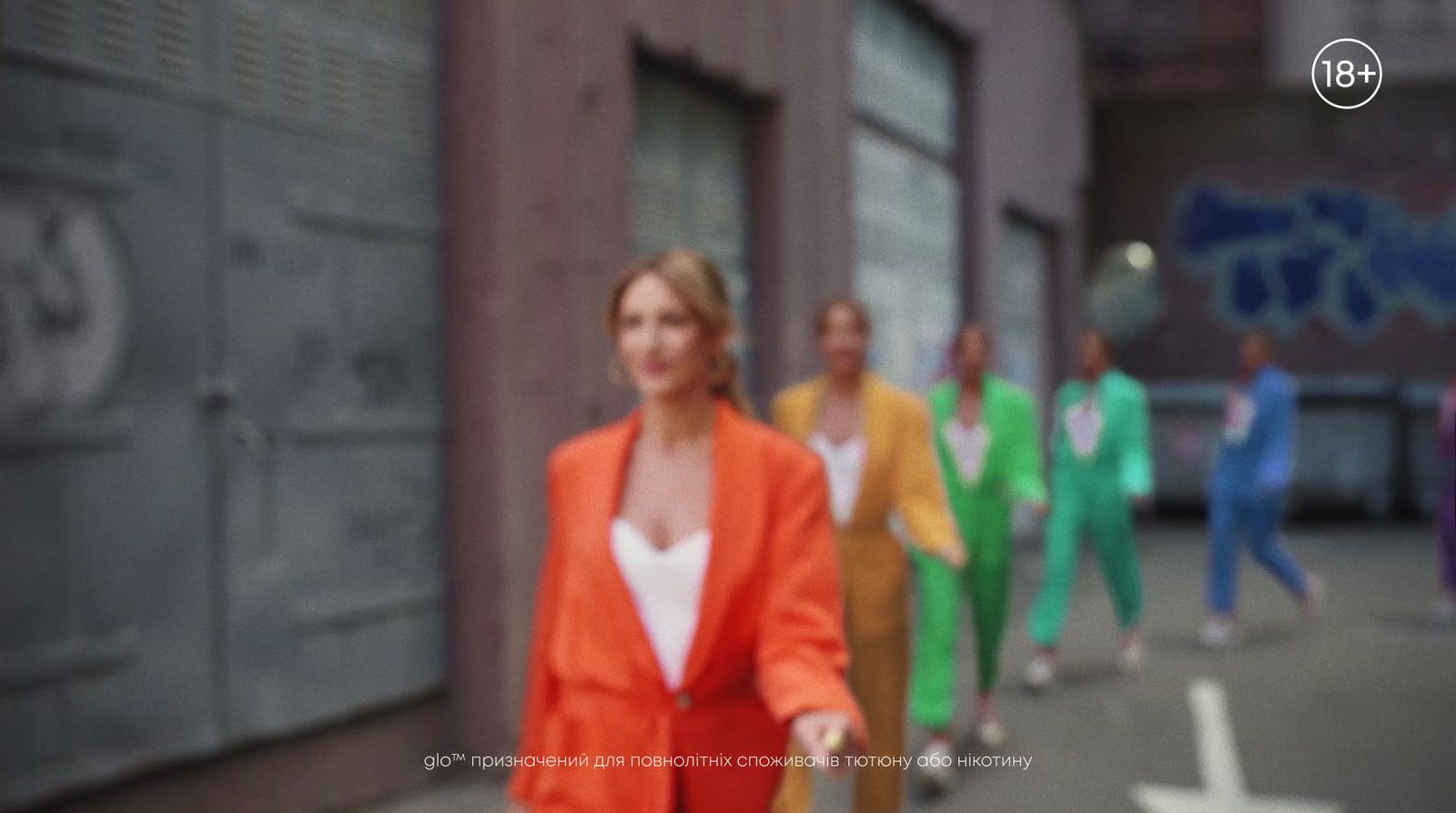 a group of people walking down a street next to a building