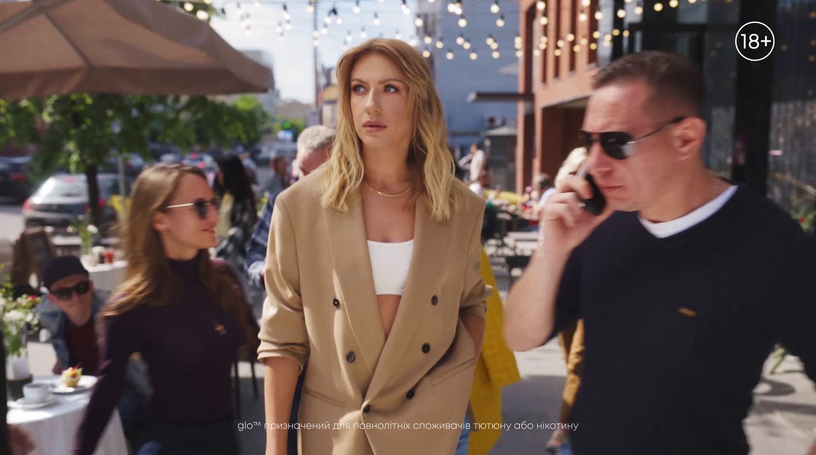 a woman talking on a cell phone while standing next to a man