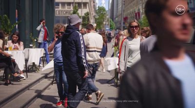 a crowd of people walking down a street next to tall buildings