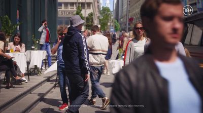 a group of people walking down a street next to tall buildings