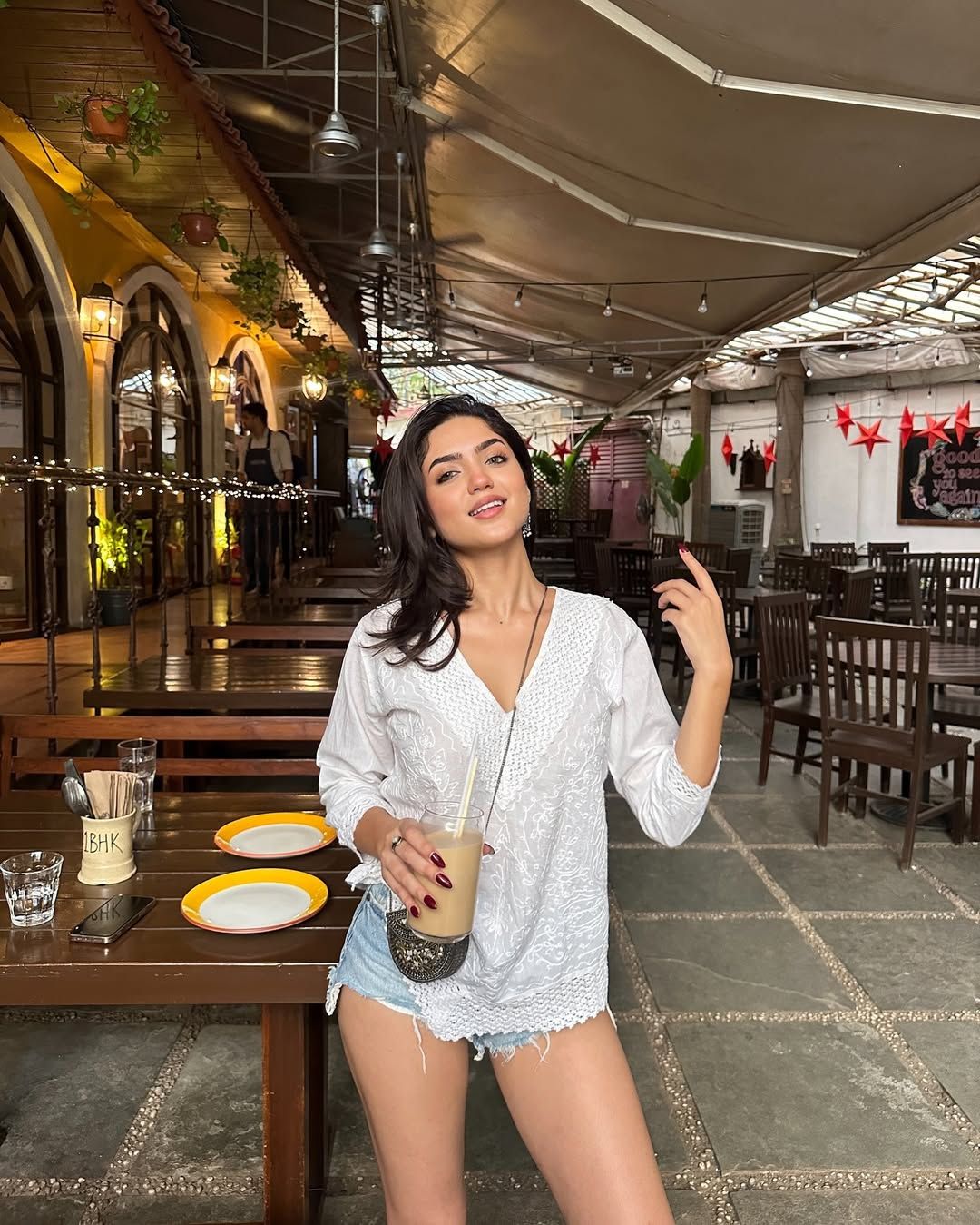 a woman standing in front of a table holding a drink