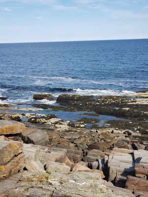 a rocky shore with a body of water in the distance