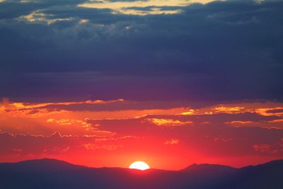 the sun is setting over a mountain range