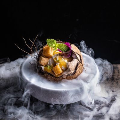 a white plate topped with food covered in smoke