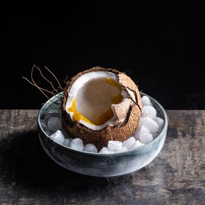 a bowl filled with ice and a cut in half coconut