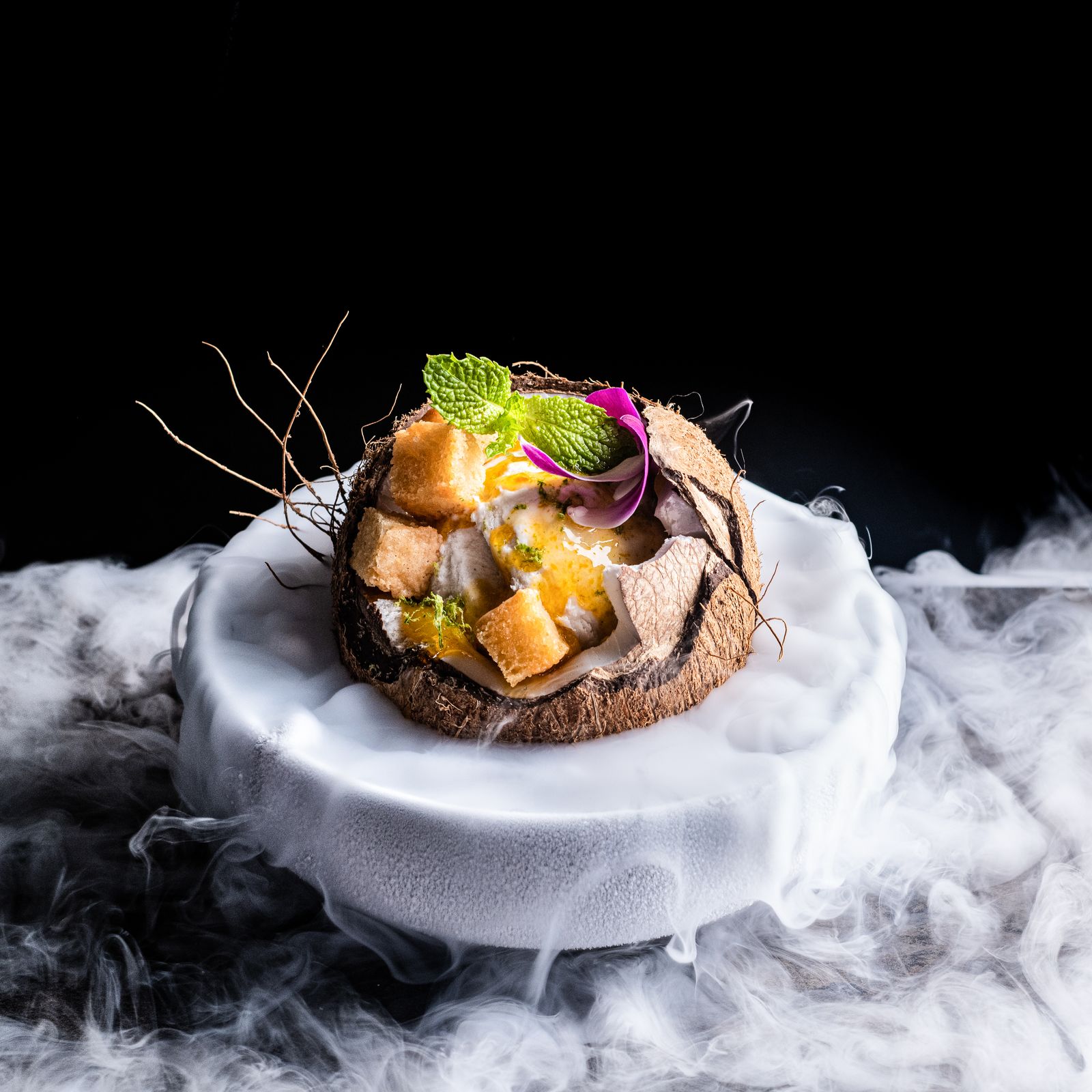a white plate topped with food on top of smoke