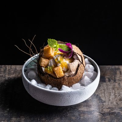 a bowl filled with ice and fruit on top of a table