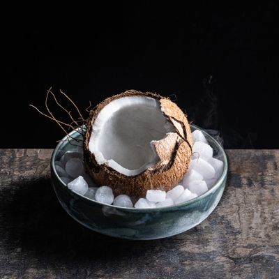 a glass bowl filled with ice and a coconut