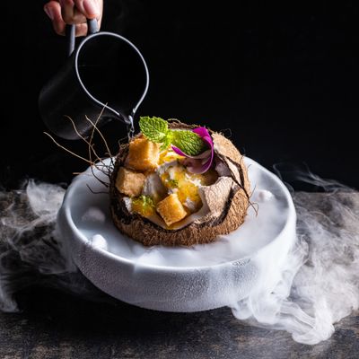 a white plate topped with a dessert covered in fruit