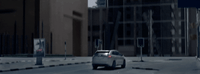 a car driving down a street next to tall buildings