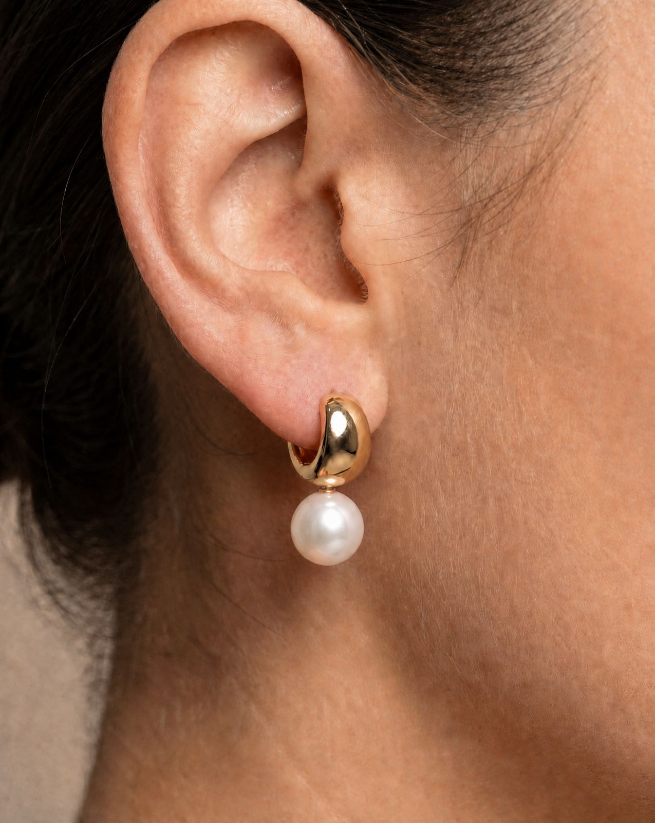 a close up of a person wearing a pair of earrings