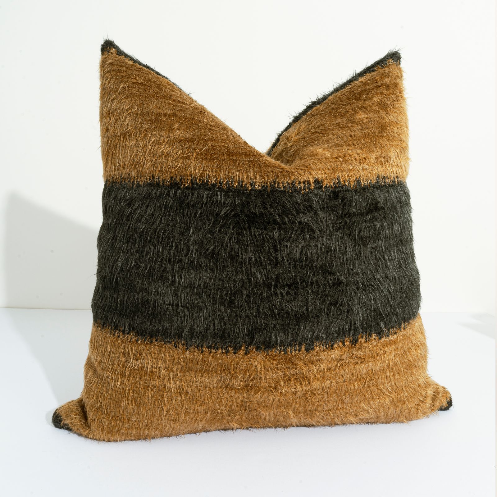 a brown and black pillow sitting on top of a white table