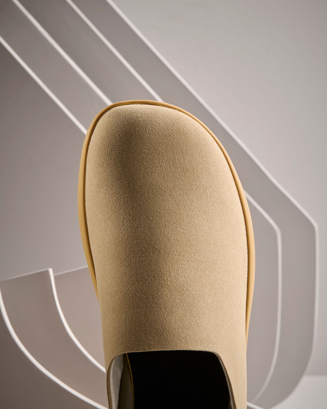 a close up of a beige shoe with a black heel
