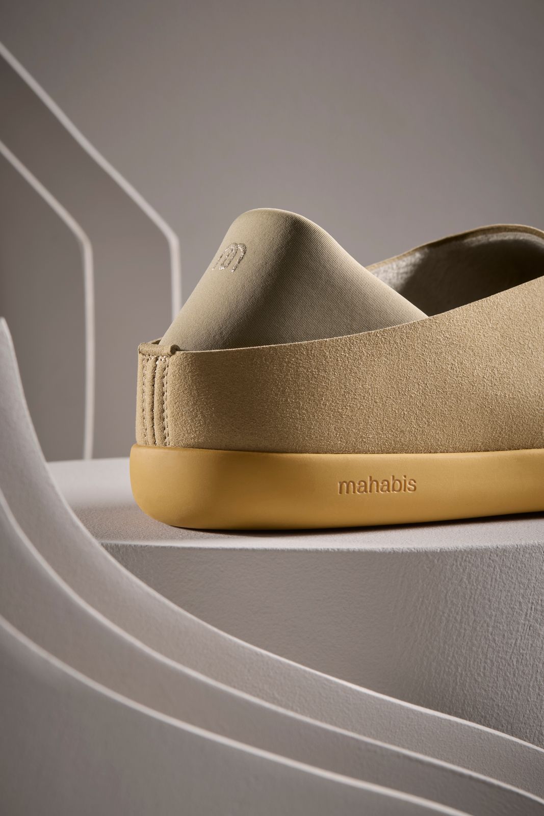 a pair of tan slippers sitting on top of a white shelf