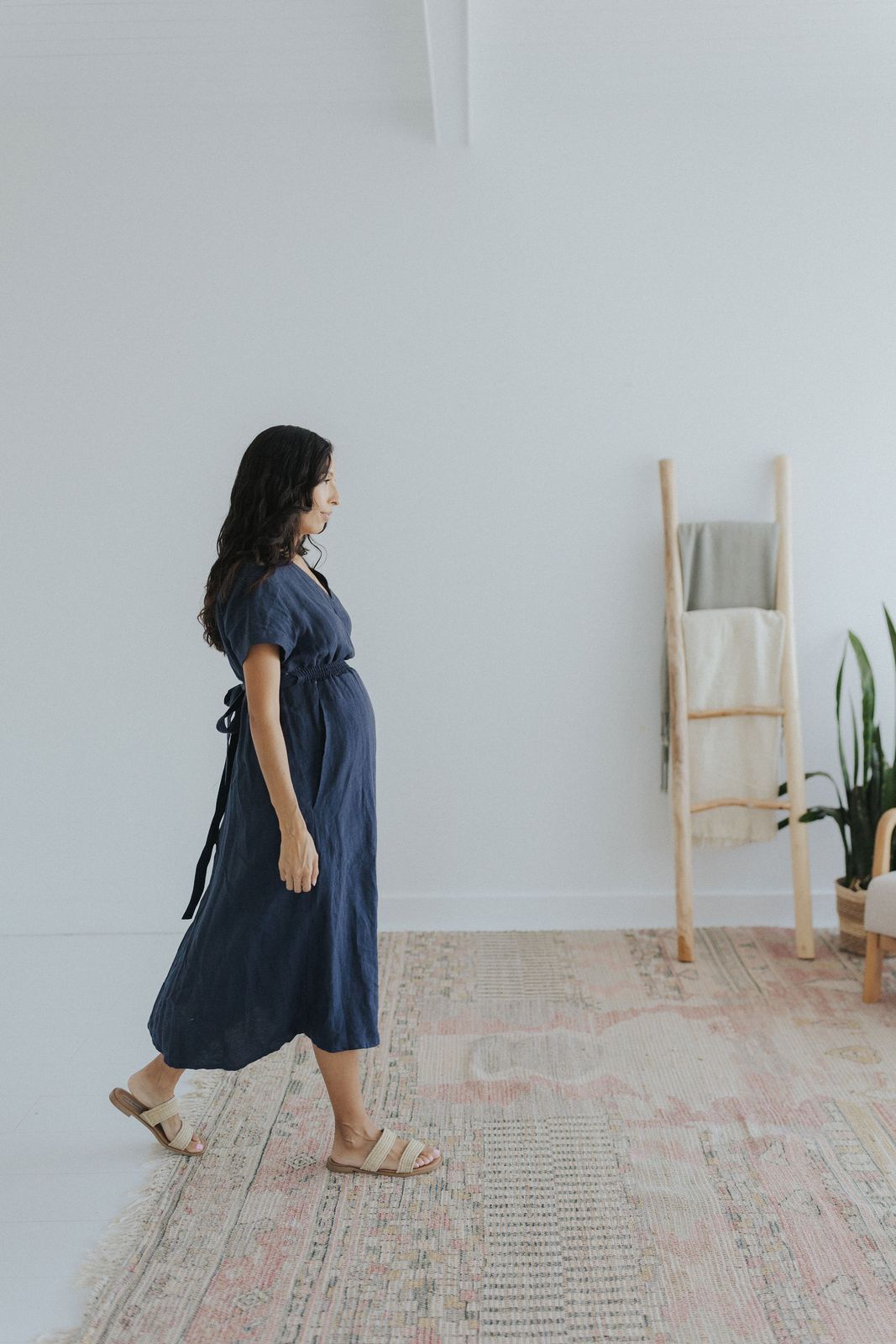 a woman walking across a rug in a room