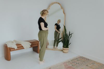 a woman standing in front of a mirror