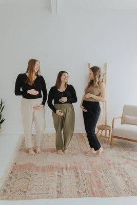 three women standing next to each other on a rug